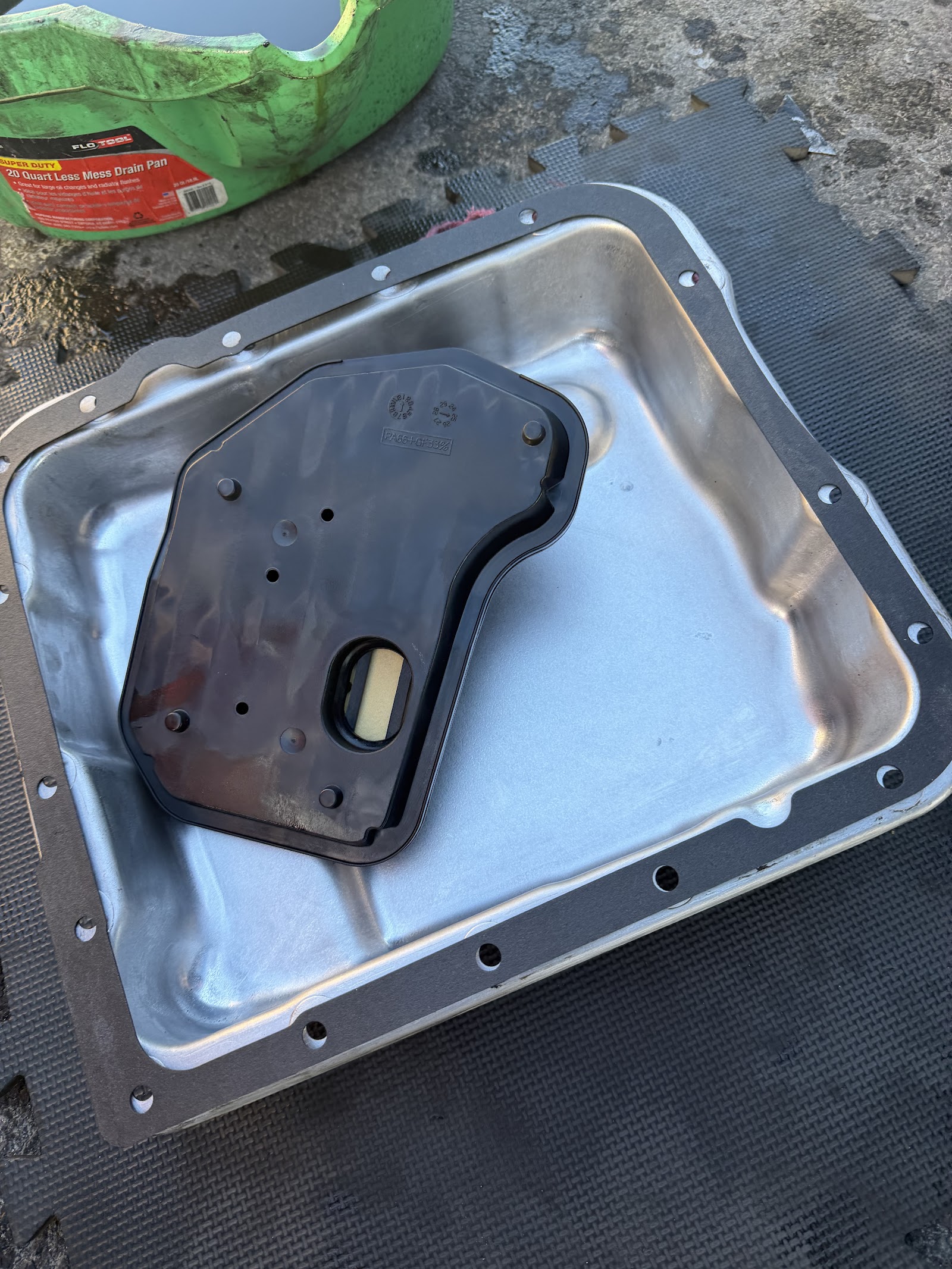 Transmission pan and filter laid out during a service on a shop mat