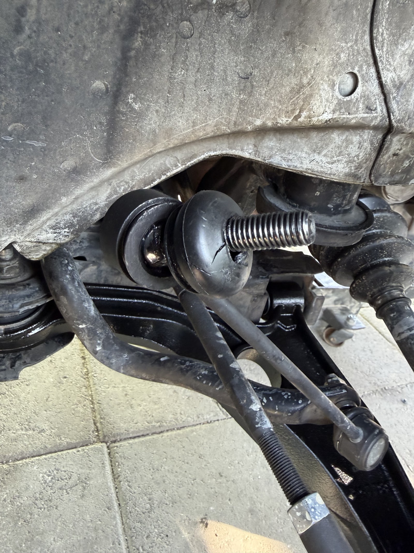 Underside suspension components showing a cracked ball joint boot
